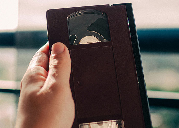 Hand holding a vintage VHS tape representing strange things private investigators discovered during their work. - 31