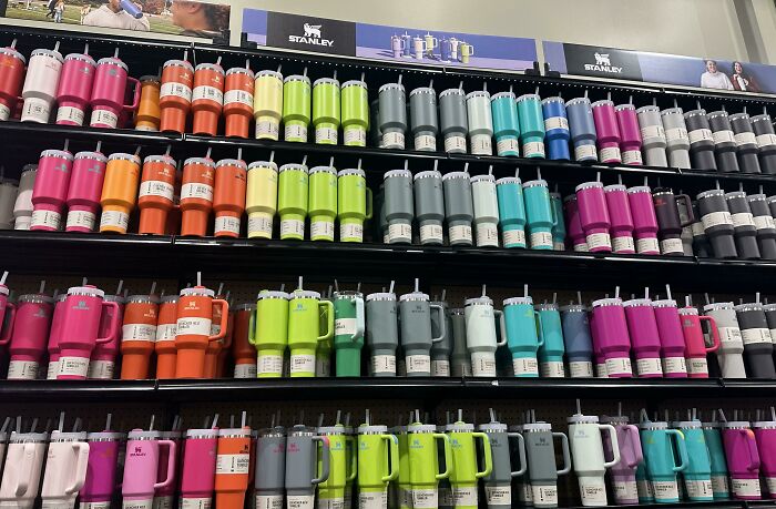 Rows of colorful reusable drinkware displayed on shelves highlighting trends contributing to overconsumption concerns. - 5