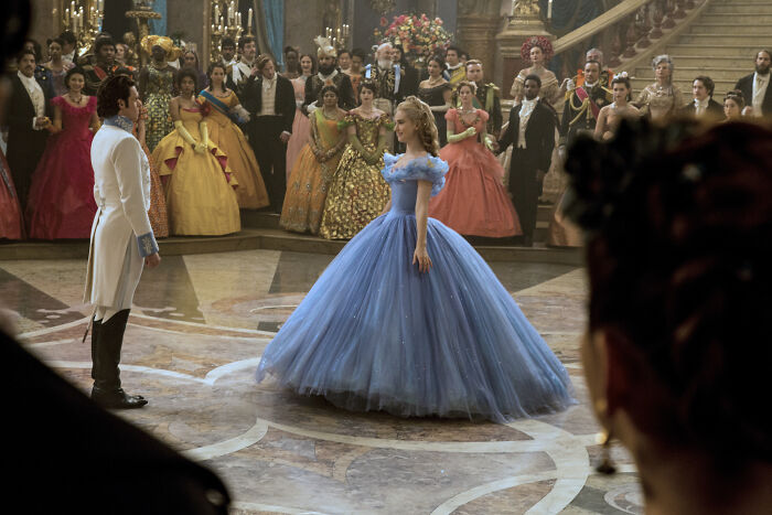 Scene from a Disney movie featuring a prince and Cinderella in a blue gown during a ball, related to rate Disney movies poll.