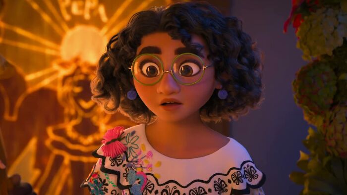 Animated character with curly hair and glasses wearing a colorful blouse in a scene from a Disney movie poll image.