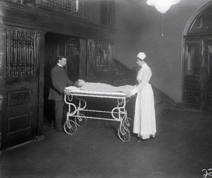 Black and white historical photo showing medical staff with a child on a hospital bed, related to interesting medical facts.