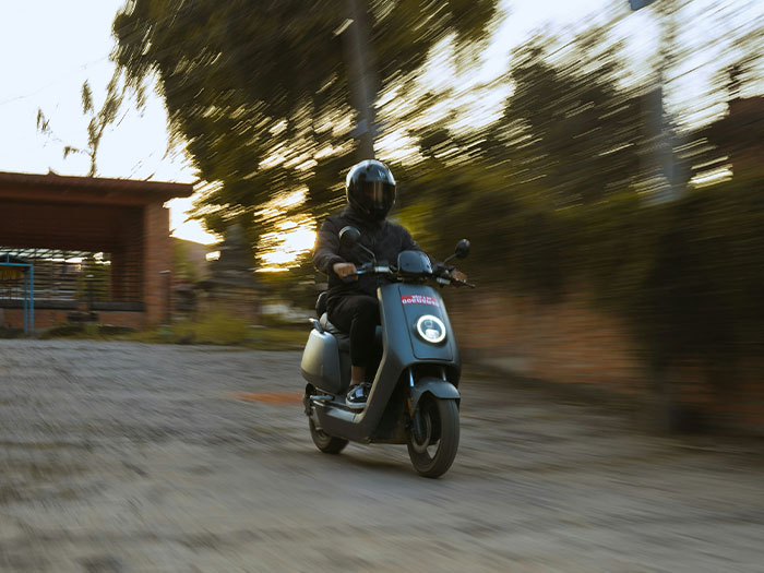 Person wearing helmet riding a scooter on a blurry road highlighting signs to avoid unsafe neighborhoods and areas