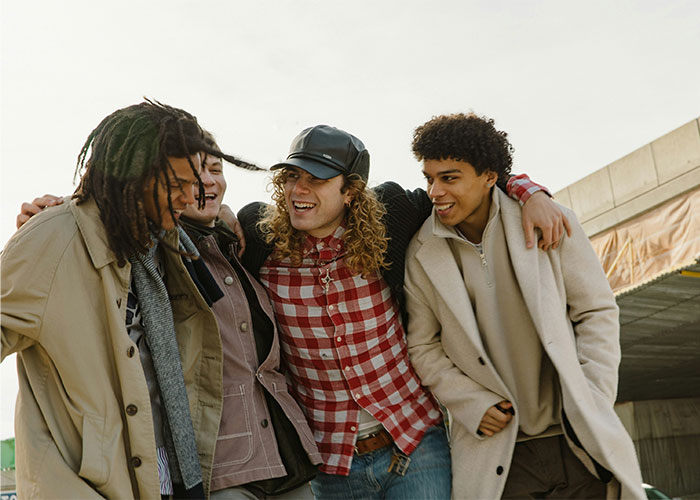 Group of friends laughing outdoors with one wearing a red plaid shirt, related to boyfriend asking and paying refusal scenario - 9