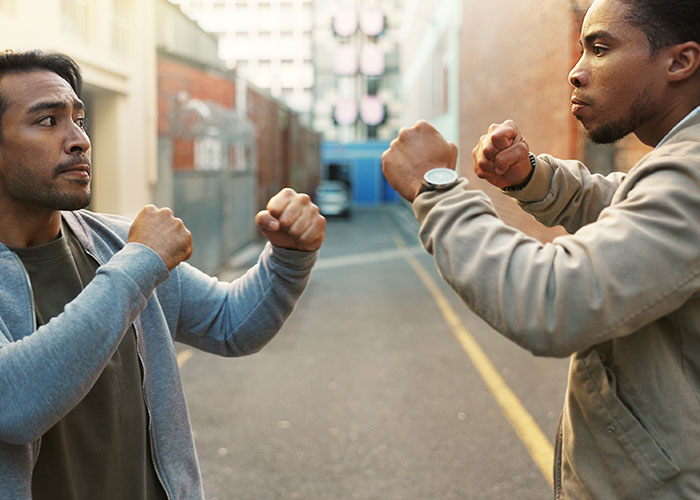 Two men facing each other with raised fists in a tense standoff, illustrating seemingly harmless things that are dangerous.