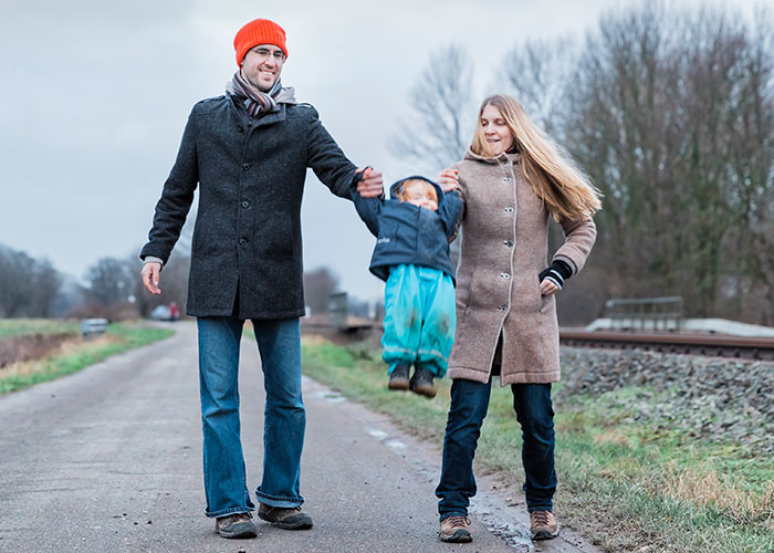 Family walking near train tracks, illustrating seemingly harmless things that are actually very dangerous.