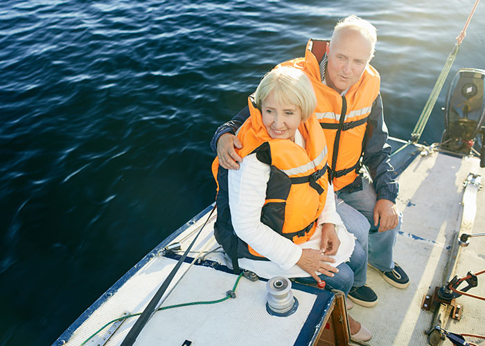 Elderly couple wearing life jackets on a boat, illustrating seemingly harmless things that can be very dangerous.