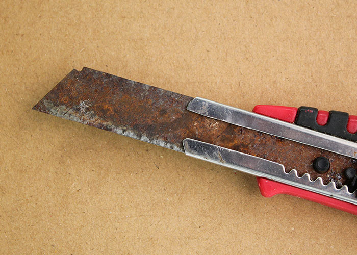 Close-up of a rusty utility knife illustrating seemingly harmless things that are actually very dangerous.