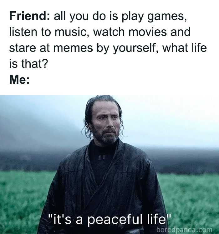 Man in dark clothing stands outdoors looking serious with social anxiety meme text about enjoying a peaceful life alone.