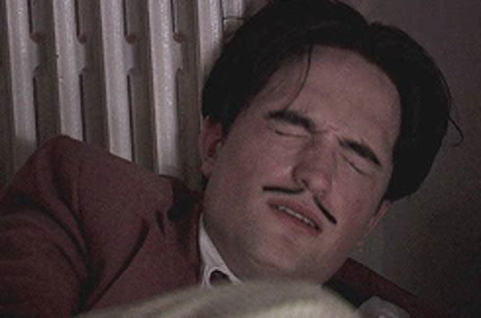 Robert Pattinson with eyes closed and mustache, portraying a challenging Twilight intimate scene moment.