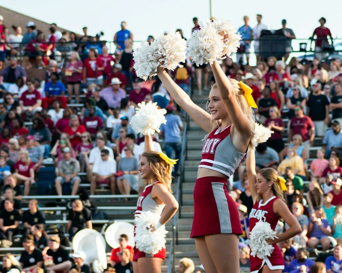 Cheerleaders performing with pom-poms at a crowded school event, highlighting memorable school incidents. - 15