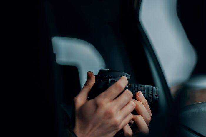 Hands holding a camera inside a car, capturing images related to weirdest cases investigated by private investigators. - 17