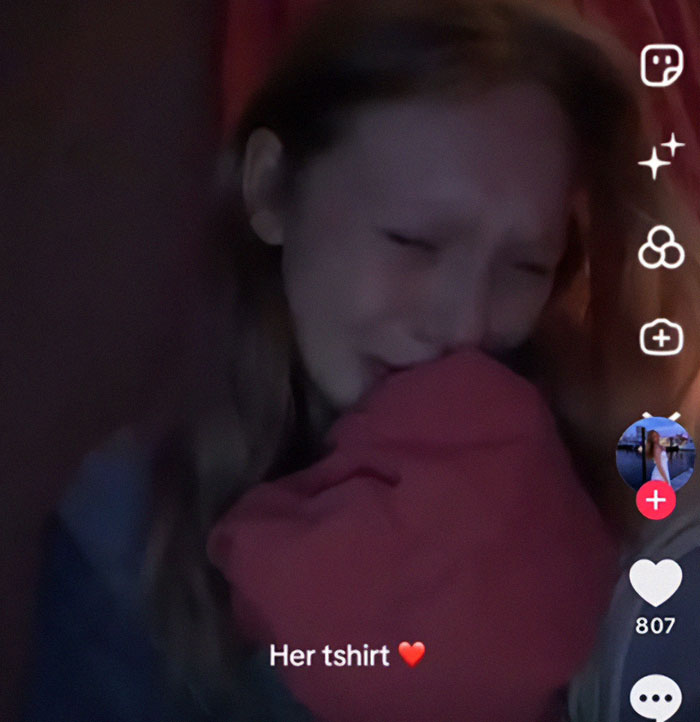 Teen girl crying and holding a red t-shirt in a dimly lit room, related to chilling eulogy and police suspicion.