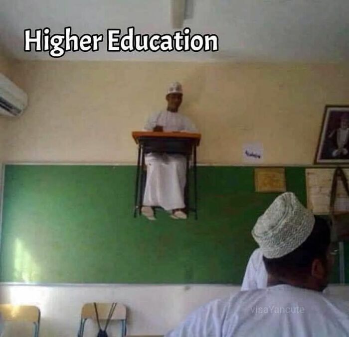 Man sitting on a classroom desk attached high on a wall with text higher education in a funny science meme.