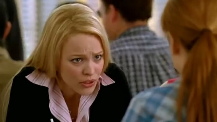 A blonde woman talking intently to a red-haired person in a crowded indoor setting, actors who auditioned for heroes.