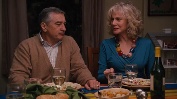 Two people sitting at a dinner table with food and wine, representing cinematic crimes in movie sequels.