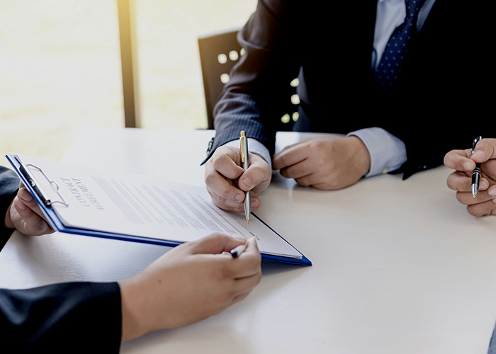 Three people in business attire reviewing a document, highlighting secrets people pray their parents never find out. - 9