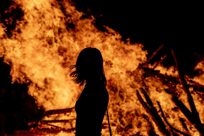 Silhouette of a person standing near a large fire, symbolizing powerful sentences that changed people's lives.