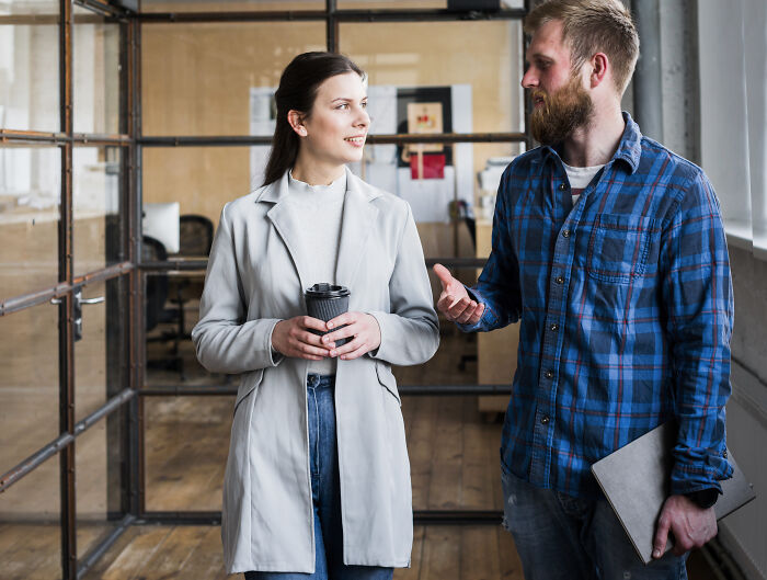 Two colleagues having a conversation in an office, illustrating sentences that changed people's lives through communication.