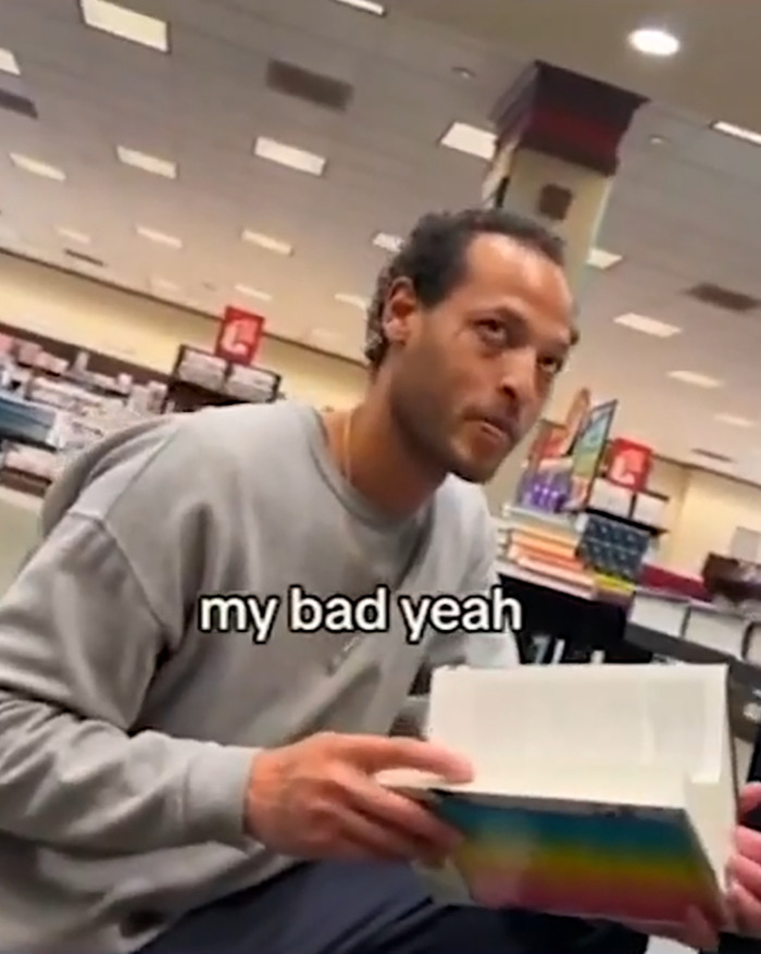 Man in gray sweatshirt holding a book inside a store related to viral serial pervert arrested after public incident. Man in gray sweatshirt holding a book inside a store related to viral serial pervert arrested after public incident.