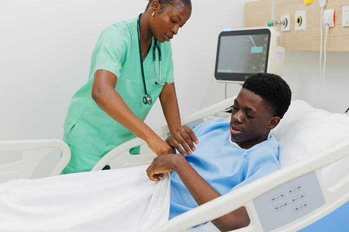 Nurse adjusting hospital bed sheets for a patient in a medical setting, highlighting serious medical conditions diagnosis.