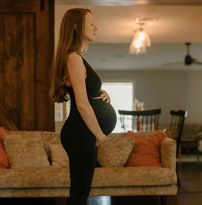 Pregnant woman standing in a living room, highlighting serious medical conditions that often take years to get diagnosed.