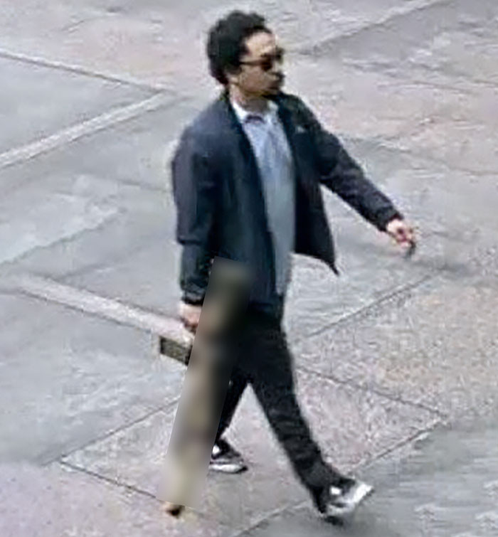 Man walking on sidewalk wearing dark jacket and sunglasses, linked to Manhattan massacre with a chilling note found. - 2