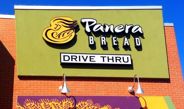 Panera Bread restaurant exterior with drive thru sign under clear blue sky, illustrating signs grew up sheltered concept.
