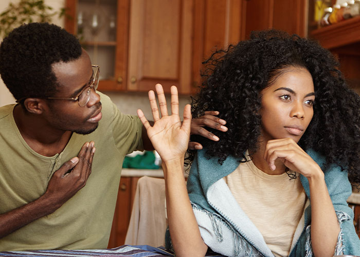 A single woman avoiding a man’s advances, showing her refusal and disinterest in a tense indoor setting.