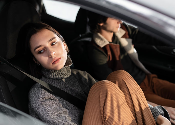 Single woman in a car looking away with a distant expression, reflecting why women avoid men like the plague.
