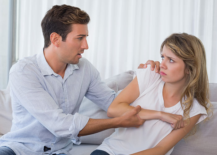 A woman looking uncomfortable as a man tries to hold her arm, illustrating single women avoiding men like the plague.