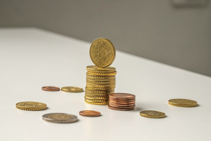 Stacked coins on a white surface symbolizing the financial benefits of working night shift for overnight workers. - 2