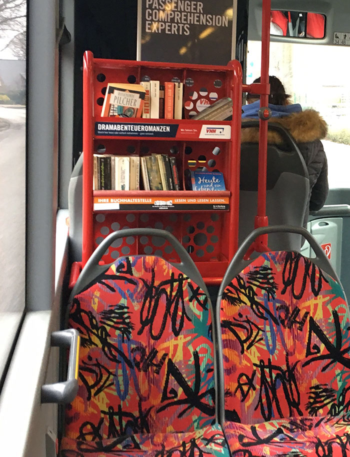 Bus interior featuring a built-in bookshelf with books, showcasing real-world design genius for convenience and reading.