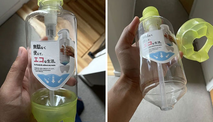 Hand holding transparent refillable soap dispenser with eco-friendly label and yellow pump cap removed.