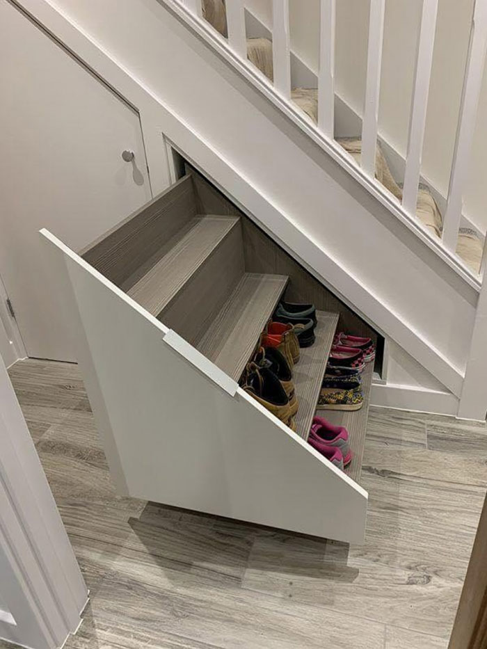 Under-stairs shoe storage with pull-out drawers showcasing genius real-world design maximizing small space efficiency.