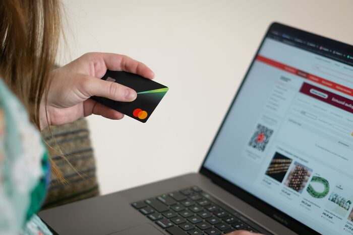 Person holding a credit card while making an online purchase, illustrating stories of sending to the wrong person. - 26