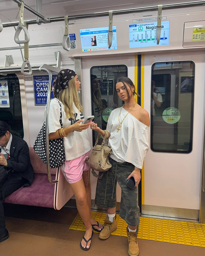 Two women posing on a Japan train during trip, related to Australian influencer criticized for tone deaf posts. - 2