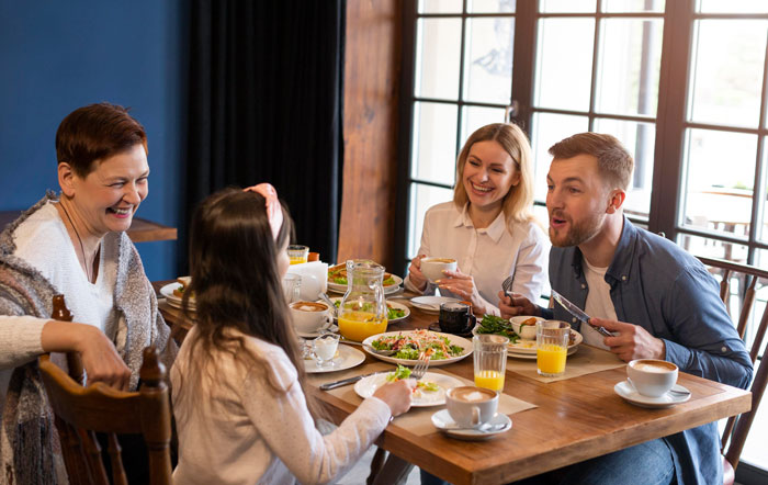 Family enjoying a meal together at a wooden table, highlighting stepkids allergies affecting birthday food choices