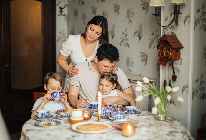 Family having breakfast together, highlighting wife and kids affected by husband's passport affordability issue. - 1