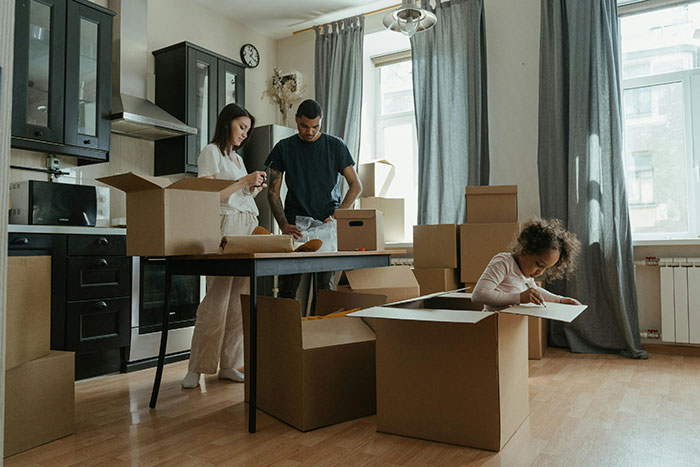 Woman and stepson unpacking cardboard boxes in new home while child plays inside a box, depicting a gold digger scenario. - 49