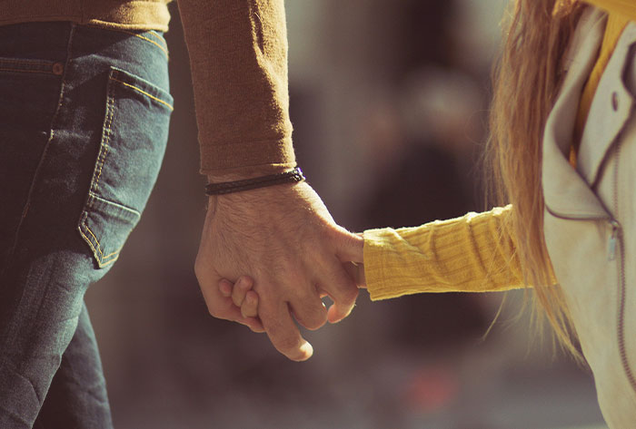 Adult and child holding hands, highlighting emotional connections in childhood stories many didn't realize were really messed up.