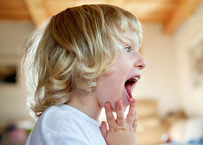 Young child with blonde hair reacting with surprise, illustrating people still upset about school punishments. - 34