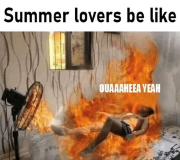 Man lying on a bed surrounded by fire with a fan blowing, humorously depicting funny summer memes about extreme heat discomfort.