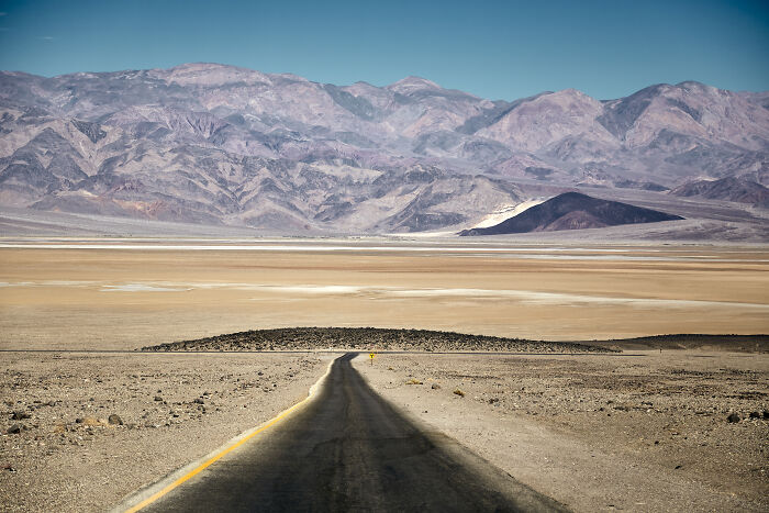 Desolate road stretching through Death Valley desert landscape, with mountains in the background, related to woman vanished case. - 2