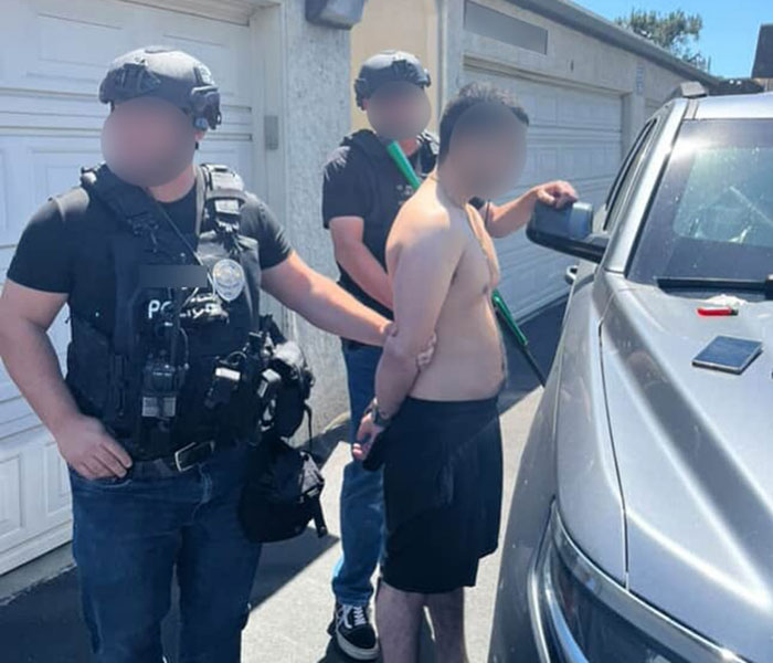 Two police officers escort shirtless man in handcuffs during an arrest, highlighting an epic police fail situation. - 4