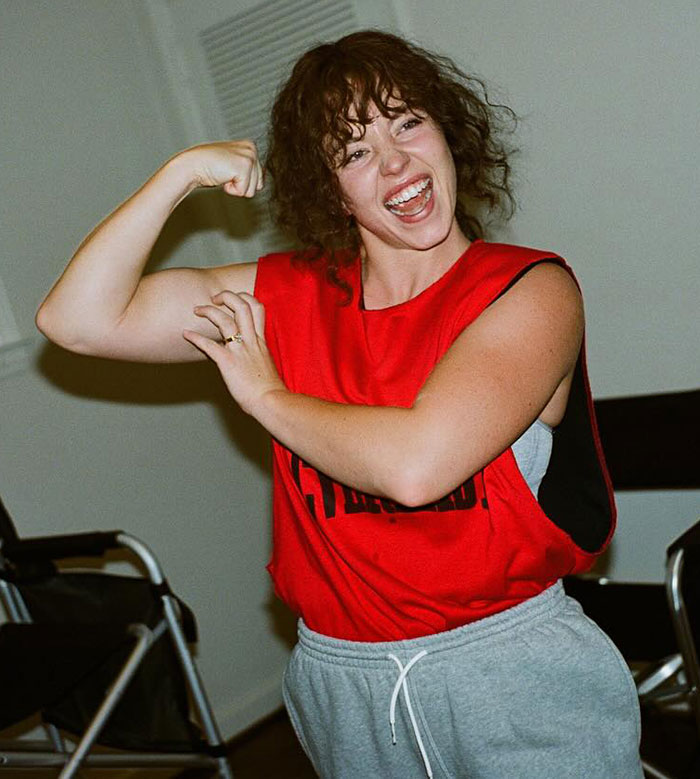 Sydney Sweeney showing off her dramatic body transformation, flexing muscles in a red sleeveless top and gray sweatpants. Sydney Sweeney showing off her dramatic body transformation, flexing muscles in a red sleeveless top and gray sweatpants.