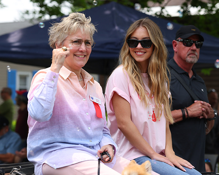 Two women smiling outdoors, one wearing sunglasses and a pink shirt, highlighting Sydney Sweeney's dramatic body transformation. Two women smiling outdoors, one wearing sunglasses and a pink shirt, highlighting Sydney Sweeney's dramatic body transformation.