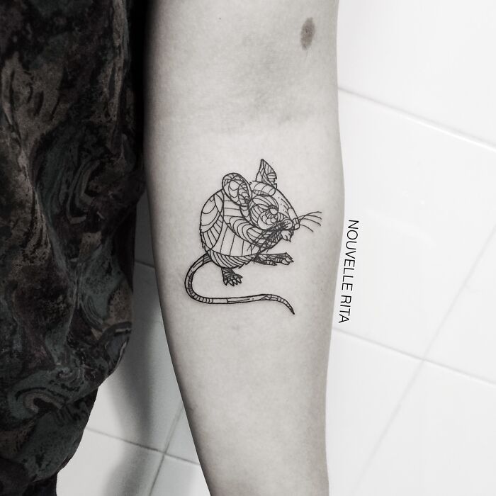 Intricate black line art tattoo of a stylized mouse on inner forearm showcasing unique tattoo design ideas.
