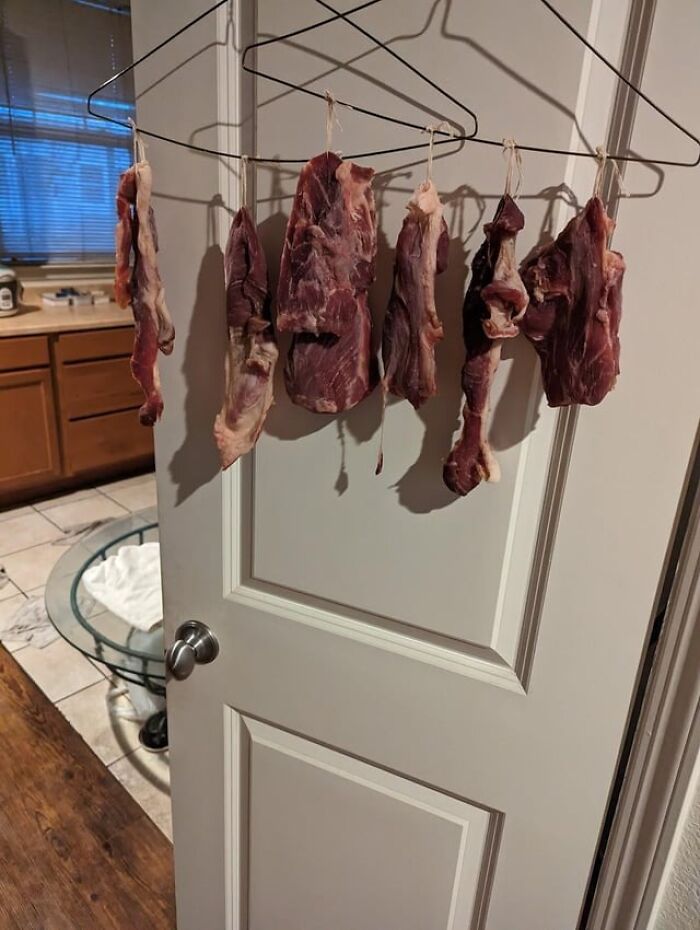 Raw meat hanging on hangers on a door in a kitchen, illustrating bad roommate behavior from Reddit tales.
