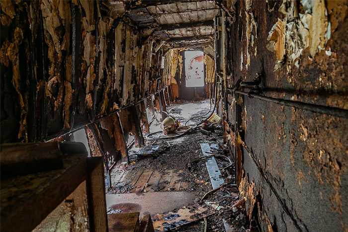 Burned and decayed interior corridor showing damage and debris, illustrating seemingly innocent things that are deadly risks.