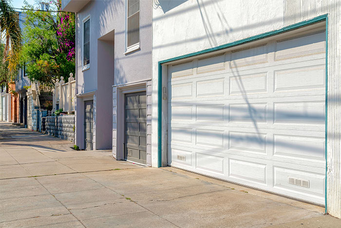 Residential street with closed garage doors and a sidewalk, highlighting seemingly innocent things that can be deadly.